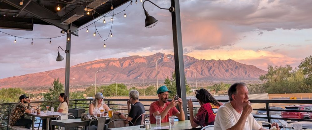 Outside deck of a brewery with a mountain at the back 