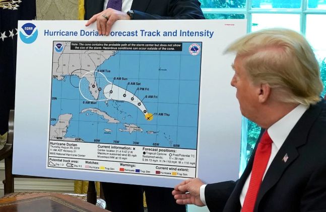 trump trying to move the path of a hurricane with a black marker
