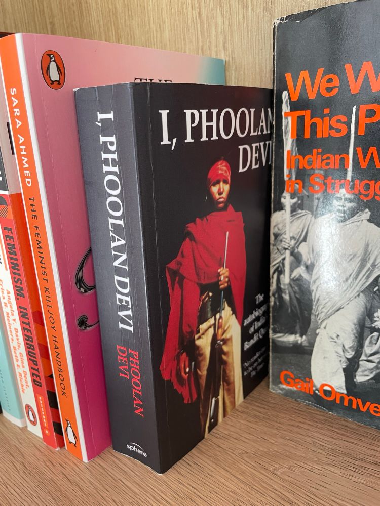 Focus on cover of book titled I Phoolan Devi on a shelf of feminist books
