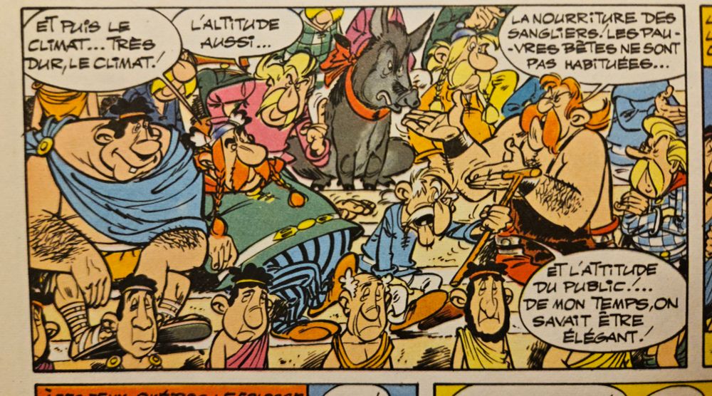 Il continue : "Et puis le climat, très dur le climat. Un autre gaulois renchéri : "L’altitude aussi", Cetautomatix ajoute " La nourriture des sangliers. Les pauvres bêtes ne sont pas habituées" Agecanonix conclus " Et l’attitude du public ! De mon temps on savait être élégants " Tout ce beau monde est bruyant et affalé au milieu des gradins composés d’un public droit et placide.