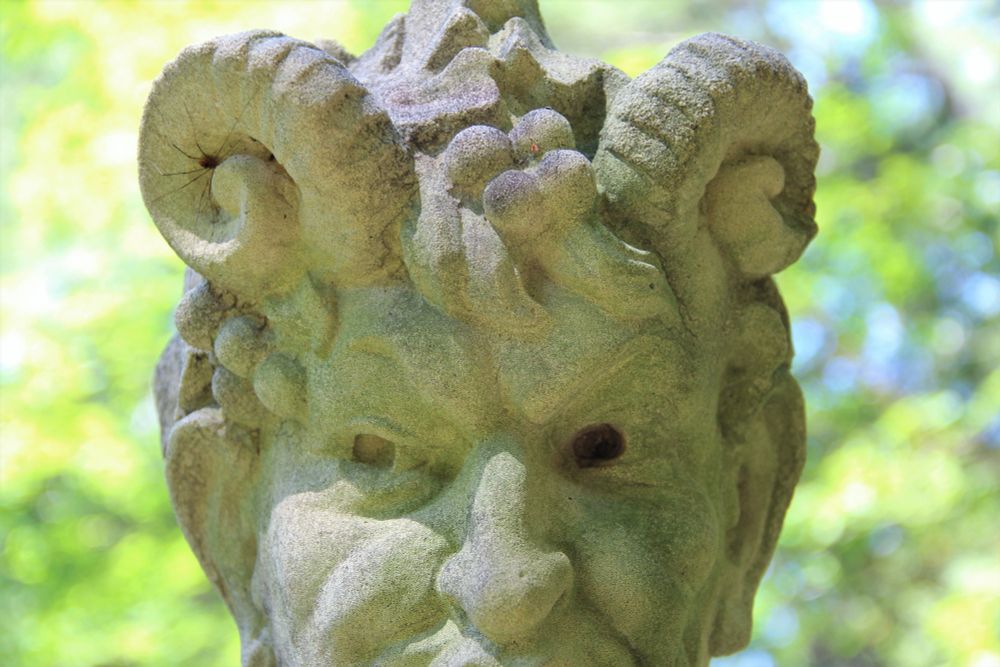 This photo shows a detail of a sculpture at the New England Botanic Garden at Tower Hill. The eyes and horns stand out in this intimidating sculpture. Pan is the origin of the word "panic" due to his ability to instill fear in those that see him.