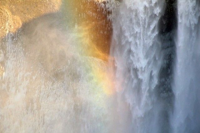 I took this photo on a January 2019 trip to Iceland. This popular waterfall was worth the hype. If you look closely to the left, you can see icicles on the rocky cliff face. The cold January air intensified the mist coming from the waterfall The angle of the sun cast a shadow in front of the waterfall, so when the light hit the mist, the rainbow it created was backed by shadow making it pop even brighter than normal. 

The photograph has a composition that's split in half. The left side is filled with mist and cliff, while the right side is filled with the waterfall. The top left corner shows the sun hitting the cliff while the rest of the photo is in shadow except for the rainbow in the center showing where the sun is coming through the mist.