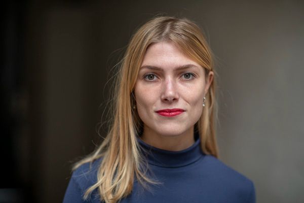 Photograph of Clara Vlessing, winner of Histoire sociale/Social History's Best Article Prize for 2024. Clara is a caucasian woman, with long blond hair, grey eyes, and red lips, wearing a blue shirt.  