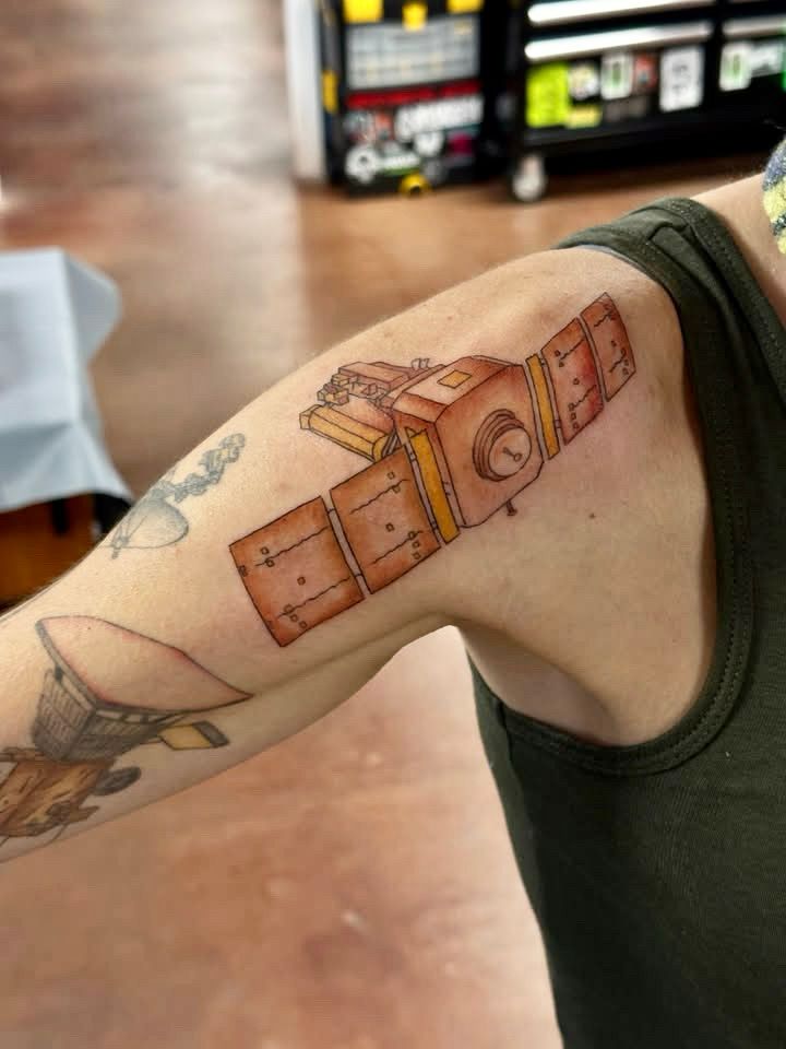 The SOHO spacecraft tattooed on a shoulder