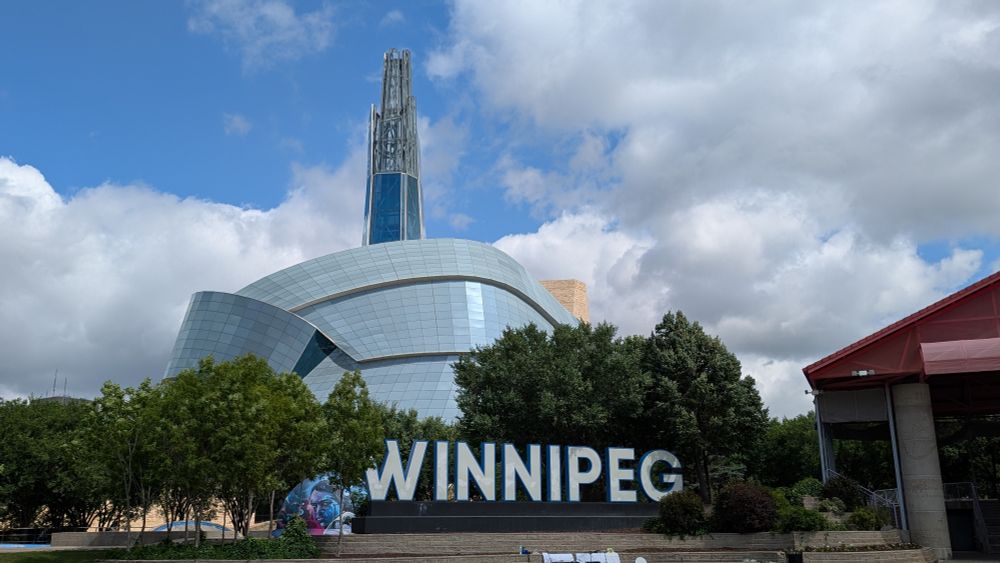 The modern architecture of the Museum of Human Rights, with the city name spelled in giant letters in front.