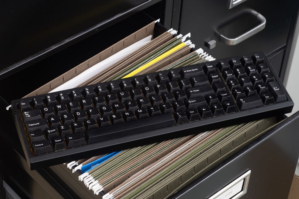 the black ASCII-F sits atop an open filing cabinet with paper folders inside. 