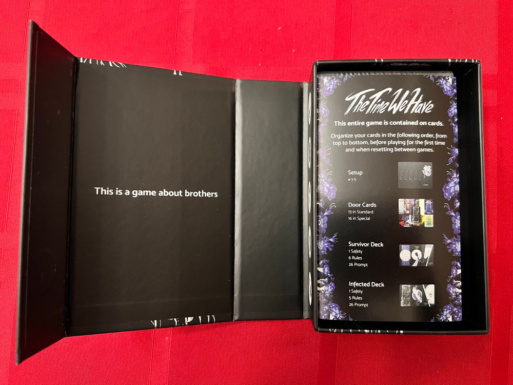 Silver and black box of the time we have open to show the inside that read “this is a game about brothers”
