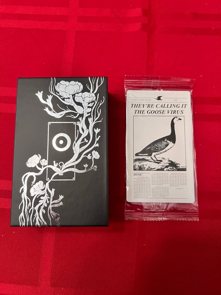 The silver and black box of the time we have next to a goose card