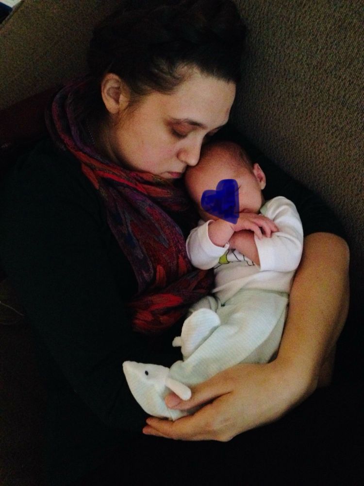 An auntie holds a tiny baby, whose face is obscured by a blue heart