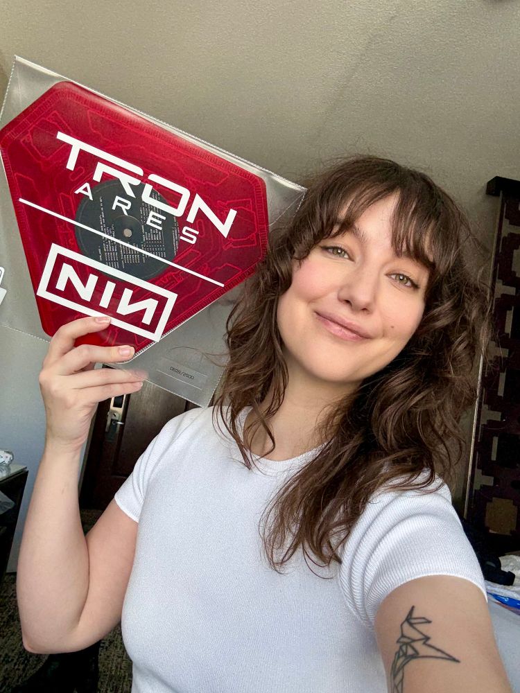 Lucy holding the SDCC exclusive TRON Ares vinyl for the new NIN song As Alive As You Need Me To Be 