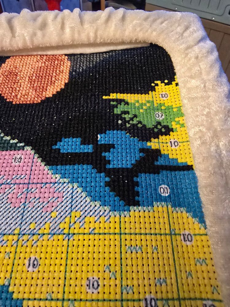 Stamped cross stitch partially completed of a sunset/horizon with image focused on a giant color block areas where I meander around the area for fun instead of going row by row in an orderly manner. #crossstitch #craftsky #stitchsky #crossstitching 