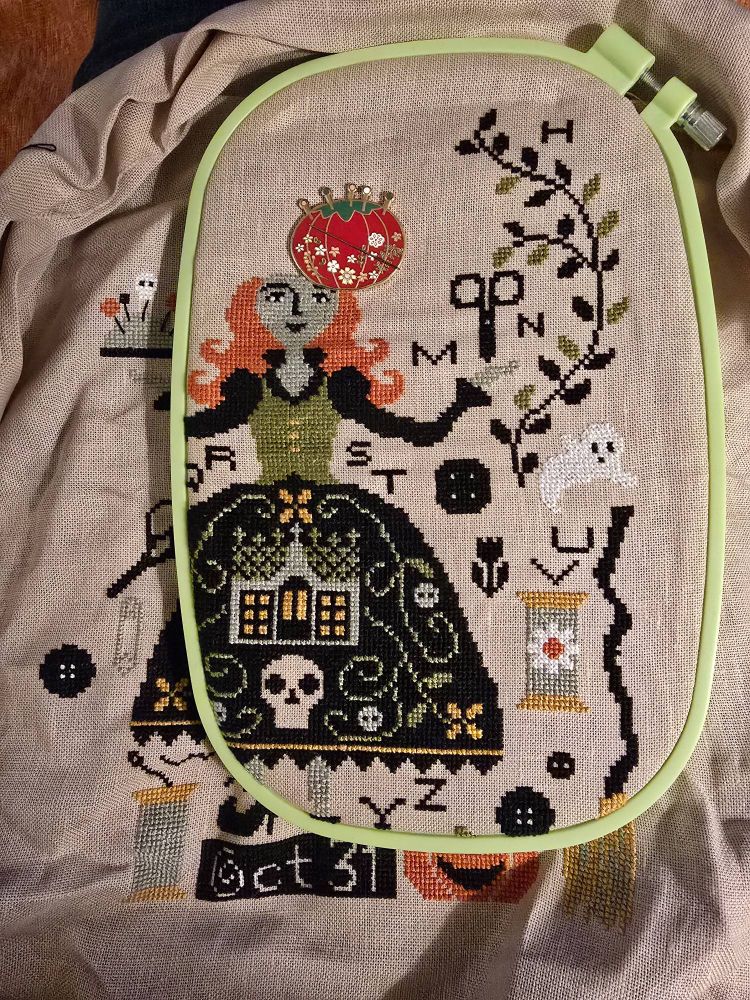 Partially completed cross stitch sampler of spooky witch surrounded by Halloween and sewing tools like scissors and buttons.  #crossstitch #stitchsky #craftsky #spooky  #crossstitching #halloween #wip