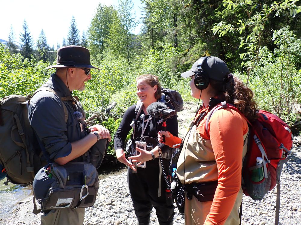 Megan Klaar being interviewed on a riverbank, with trees behind. By Mark Smith.