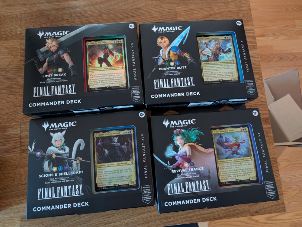 Set of four MTG Precon Commander decks (Cloud, Tidus, Y'shtola, Terra) on a table.