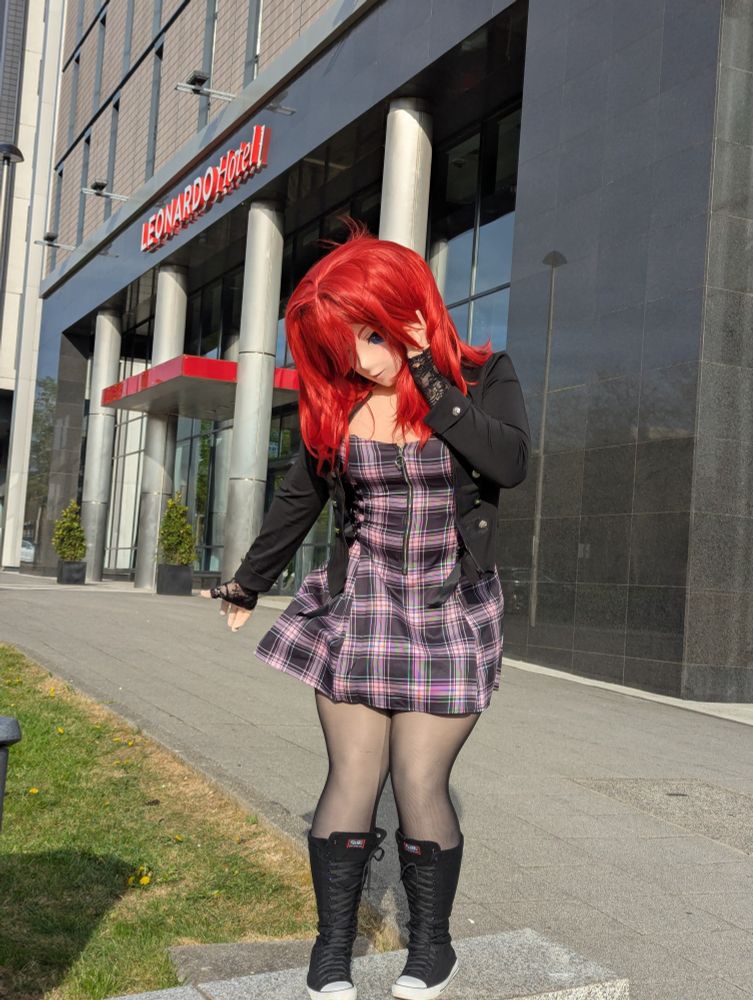 Scarlett in front of the hotel, standing on a raised kerb, looking down and trying to figure out how to get down safely.