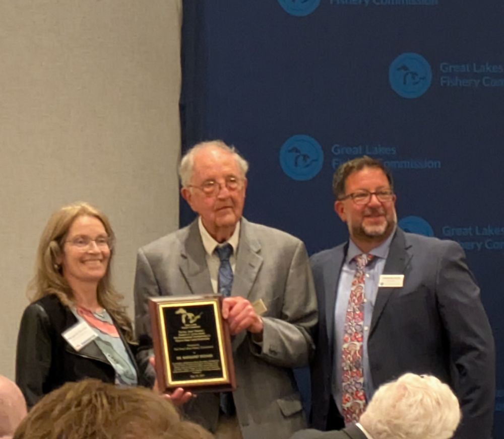 Dr. Docker receives the award from Drs. Hecky and Muir. Everyone is well dressed and Andrew has a great tie.