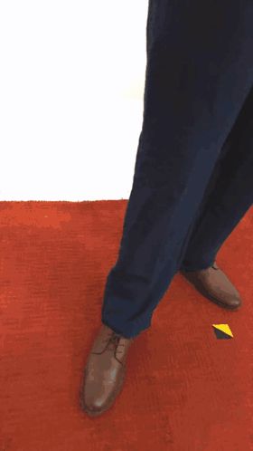 a person wearing blue pants and brown shoes is standing on an orange carpet