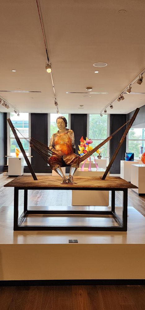 Image of a glass sculpture of a pregnant woman from a distance 
