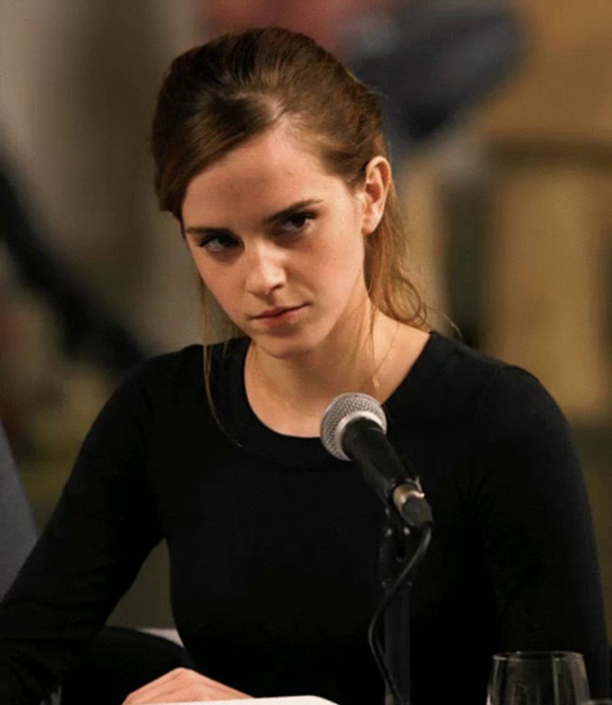 a woman sitting in front of a microphone with a ponytail