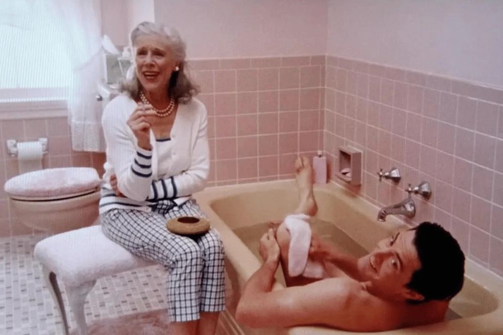 kyle maclachlan as trey in sex and the city taking a bath as his mother sits on a stool next to him smoking a cigarette