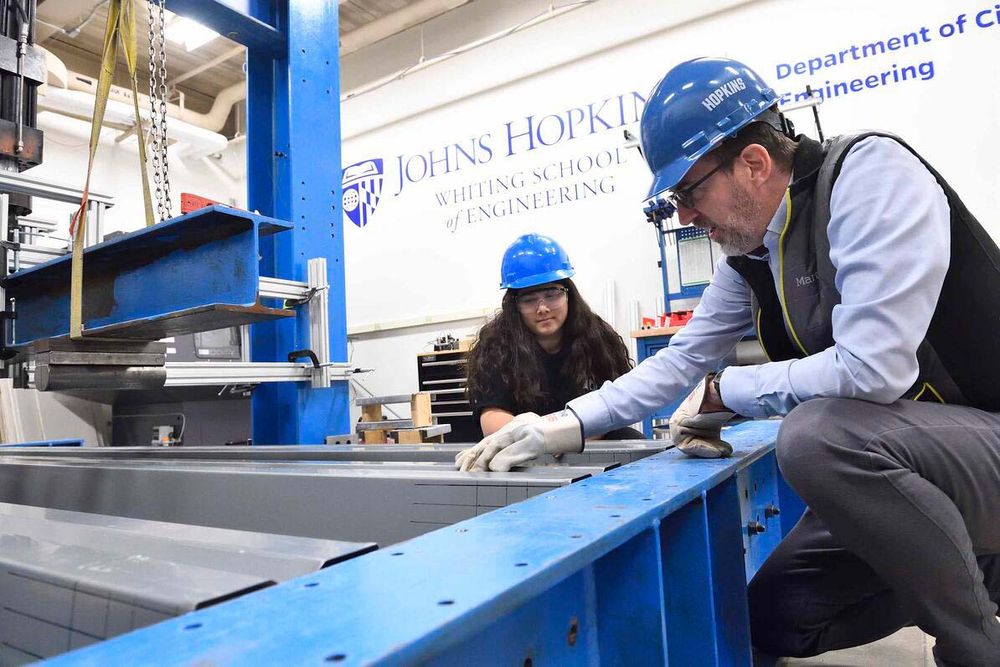 Ben Schafer and a grad student inspect steel in a laboratory