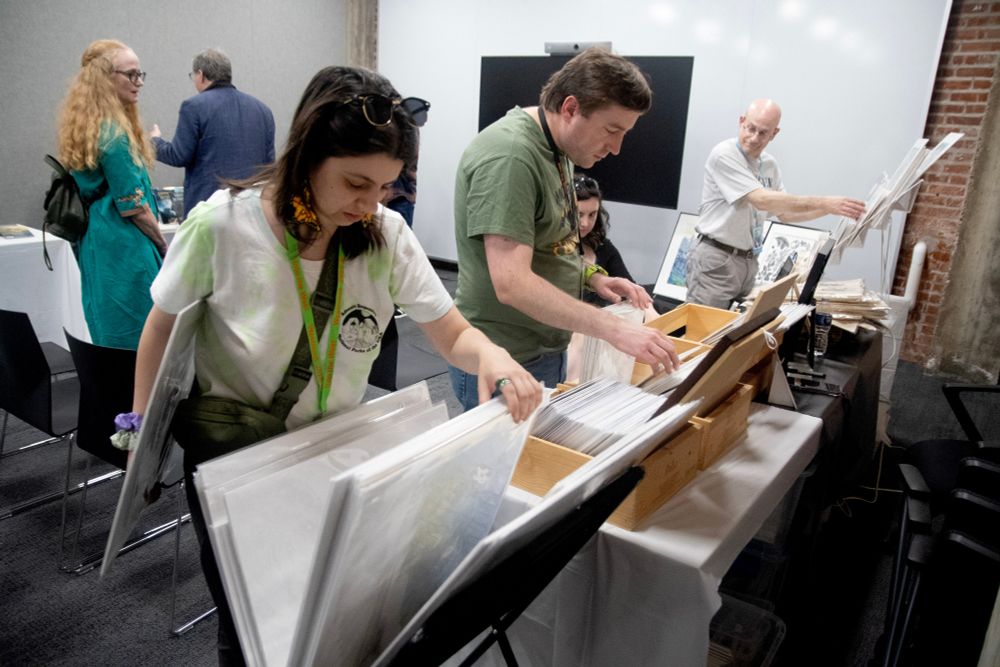 Westmoot attendees looking through matted artwork.
