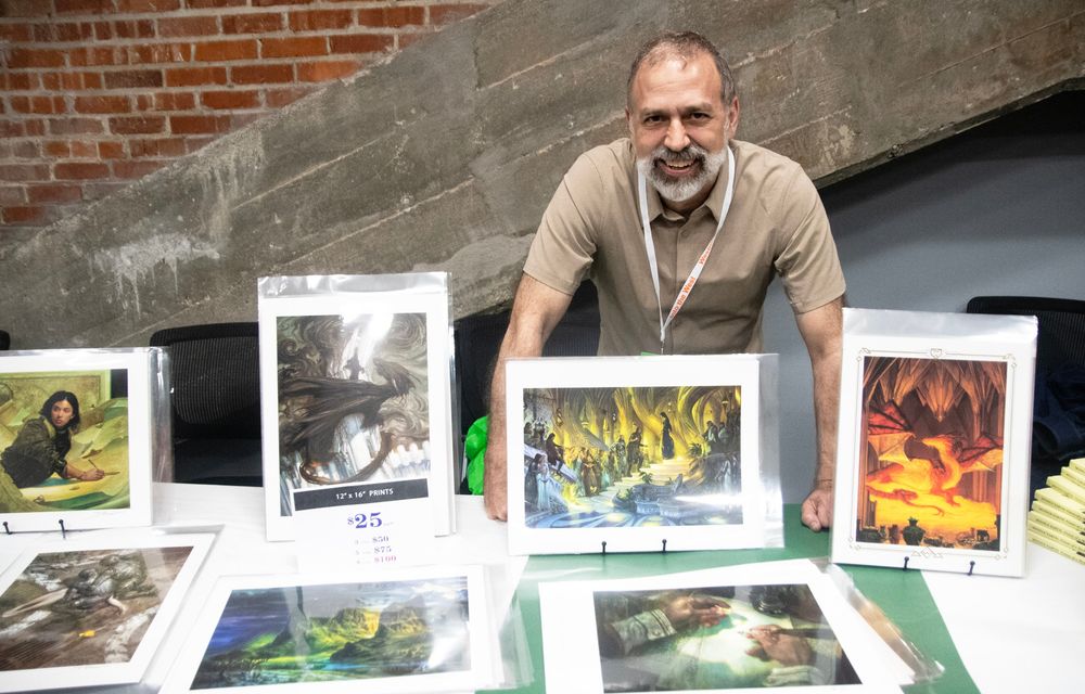 Westmoot Keynote speaker, artist Donato Giancola, poses with his artwork. 
