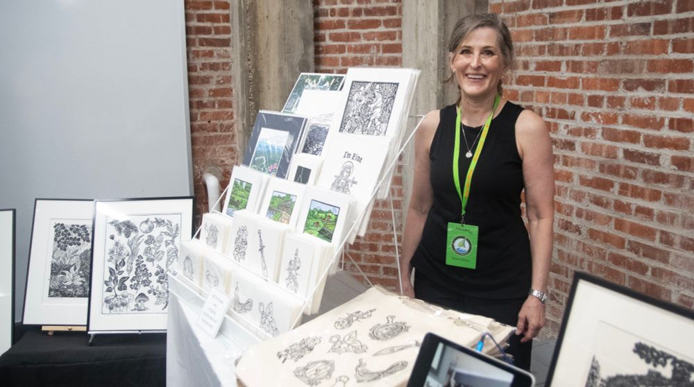Tamsin Barlow stands with her artwork.
