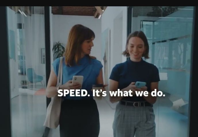 A picture of two well-dressed twentysomething-to-thirtysomething white women walking down a hallway in a fancy modern corporate space, holding their phones and chatting and smiling, under the caption, "SPEED. It's what we do."
. 
. 
. 
. 
 
 
. 
. 
. 
. 



It is from an AT&T ad. 😭