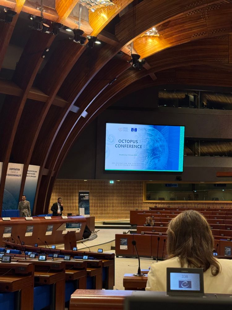 View of the hemicyle room at Council for Europe, with a screen showing dates and details about the Octopus Conference