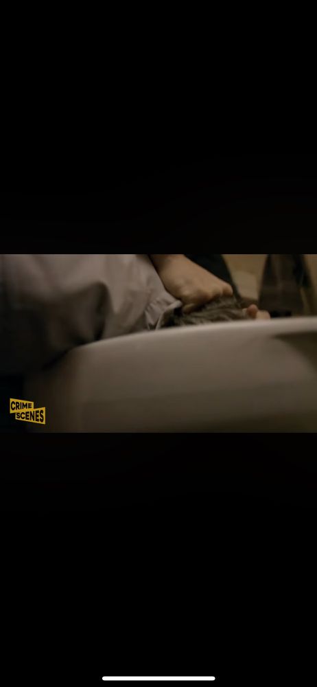 He’s dunking the guys head in the toilet bowl. 