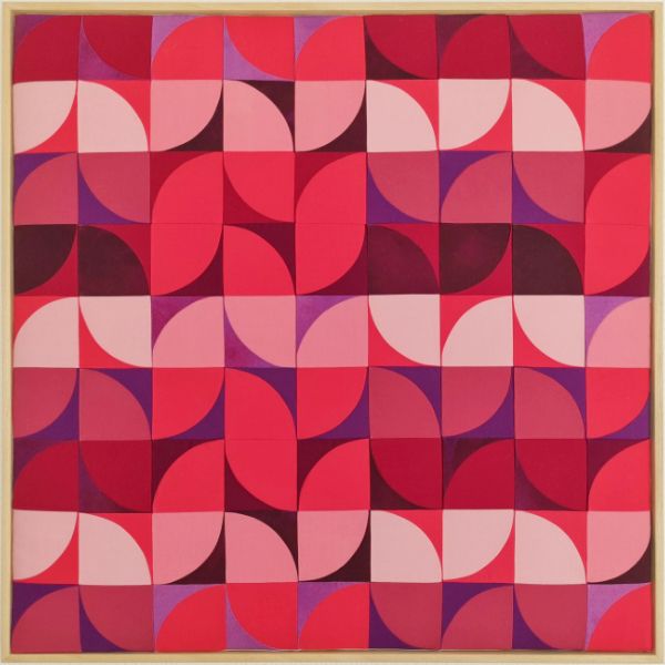 Modern quilt with a geometrical, abstract leave design in several tones of red and violet.