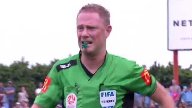 a referee wearing a green shirt with the word fifa on it .