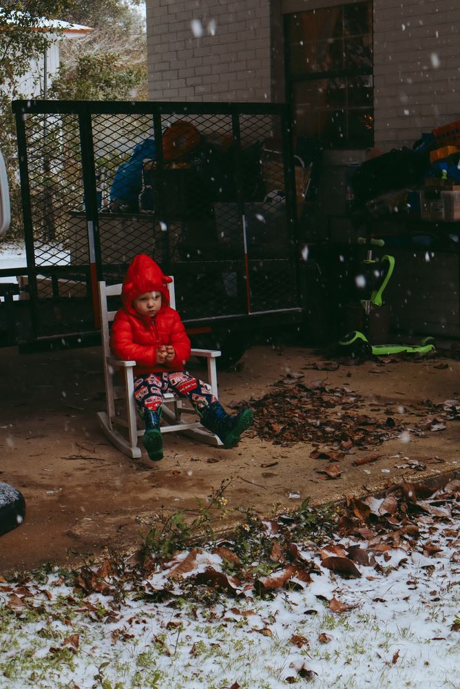 My 2 year old son sitting outside during the gulf coast snow storm in Florida