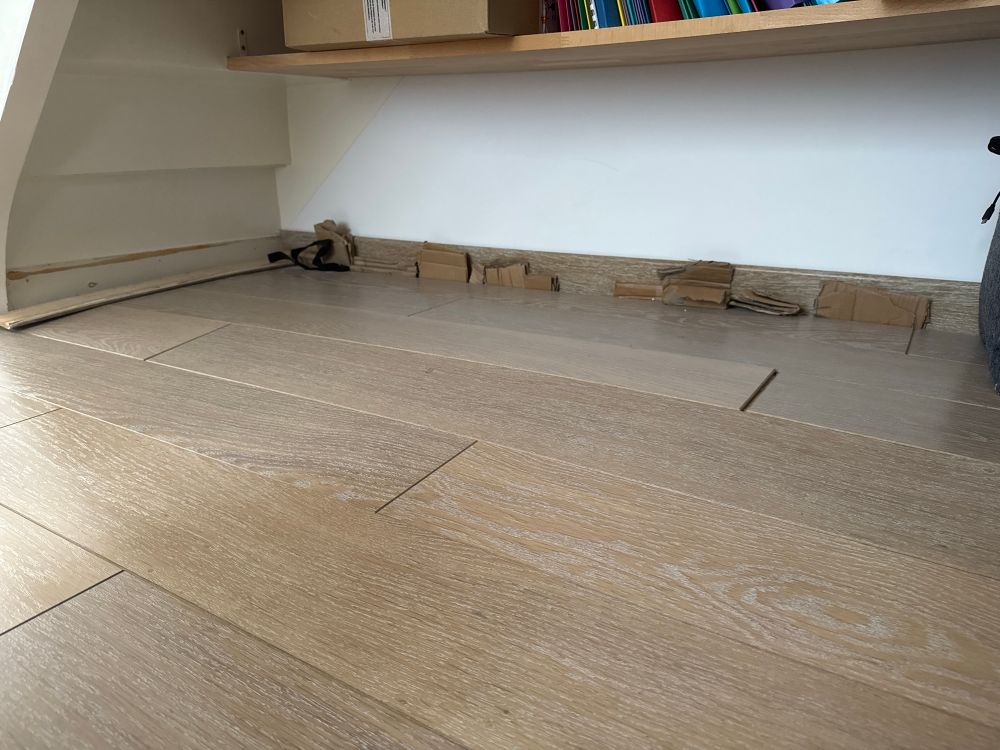 Le parquet est gondolé. Les plinthes tiennent grâce a du carton.