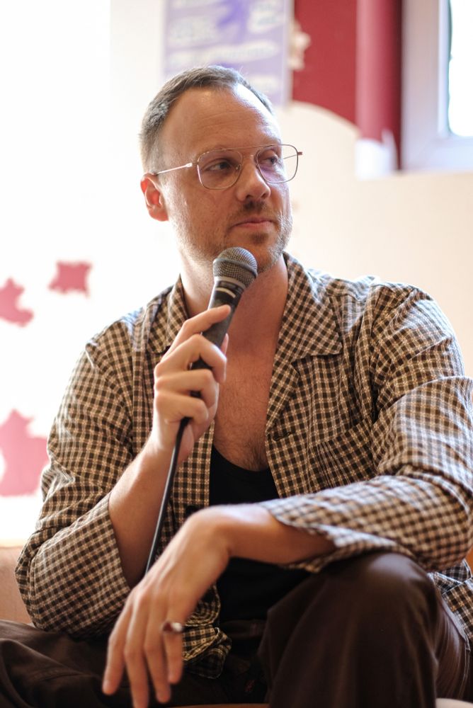 Photo depicting a person holding a microphone and listening.
