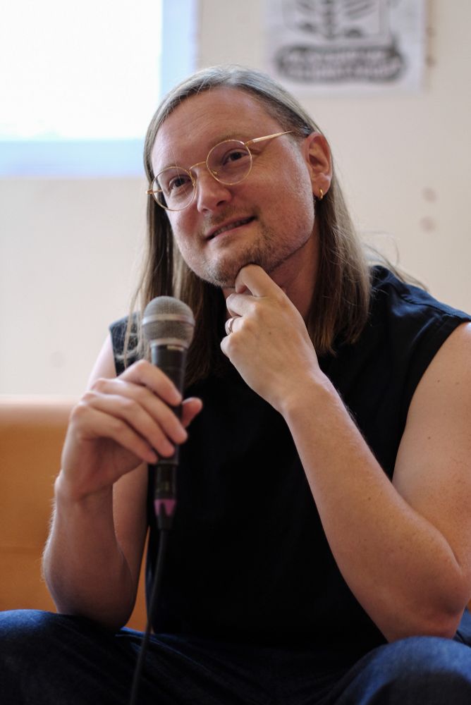 Photo depicting a person in contemplation while holding a microphone.