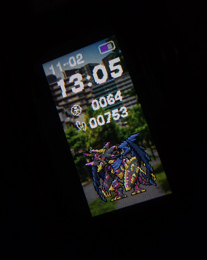 Photo of a vital bracelet in the dark displaying Regulusmon.