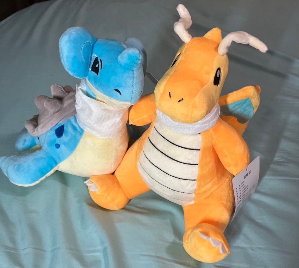 Lapras plush and a dragonite plush with scarves made of paper towels 