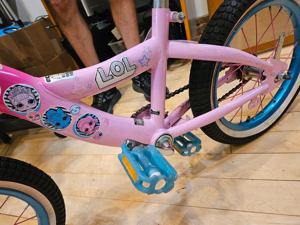 A pink "puzzle bike" is in need of just a touch of TLC after students from SLPS's Humboldt Academy in Soulard accidently put one of the pedals on the under-bike side of a crank arm :) Appropriately, the frame of the puzzle bike has a sticker on it that happens to say "LOL"