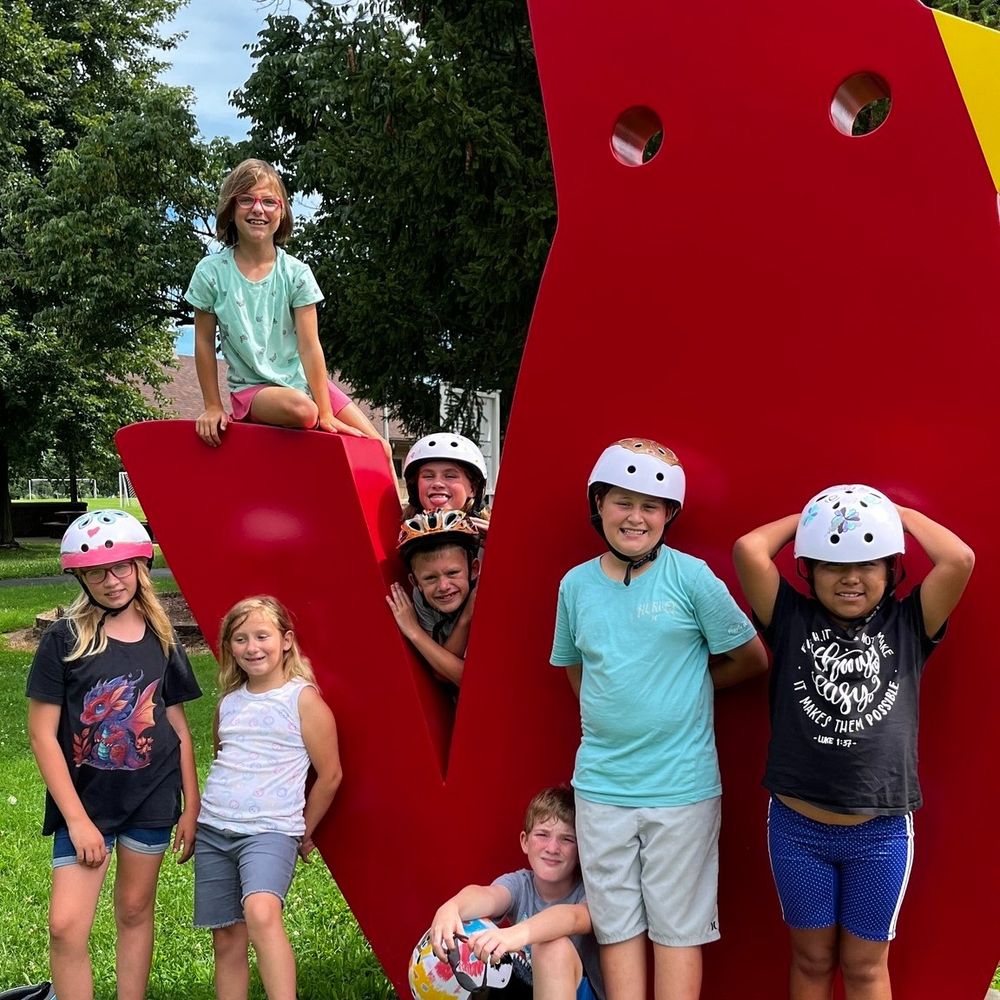 Eight students who took part in BWorks' six-week Earn-A-Bike program during their YMCA camp in Maryville, Illinois, pose with an MCT Trail "critter" sculpture along an MCT trail they got to ride as part of their BWorks graduation on Monday.