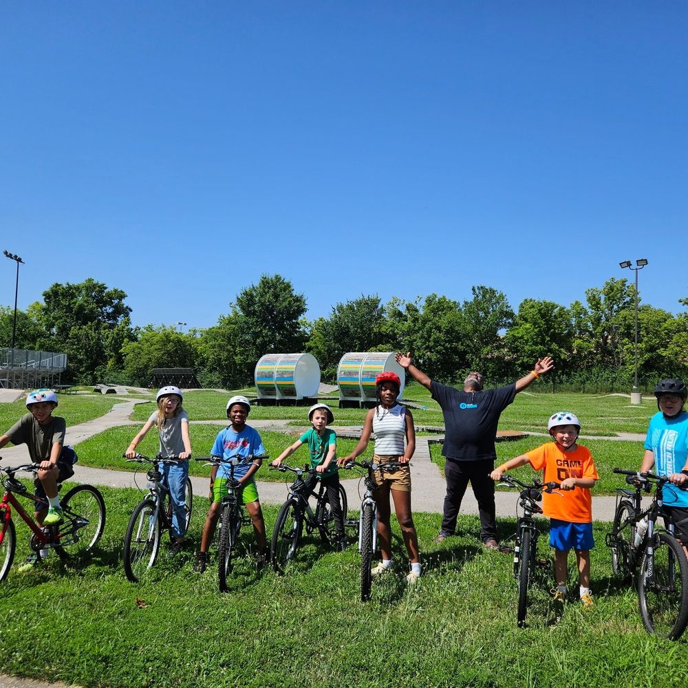 Earn-A-Bike teachers Mark and Susie join six Earn-A-Bike students at Kinetic Park for a quick pic before a ton of fun on the skills course.