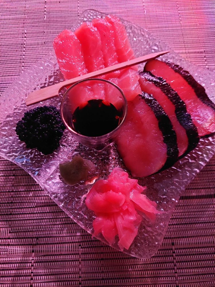 Auf kleinem Glasteller: Sashimi Lachs und Thon, Pink Ingwer, Fischsauce und als Extra ein wenig Kaviar.