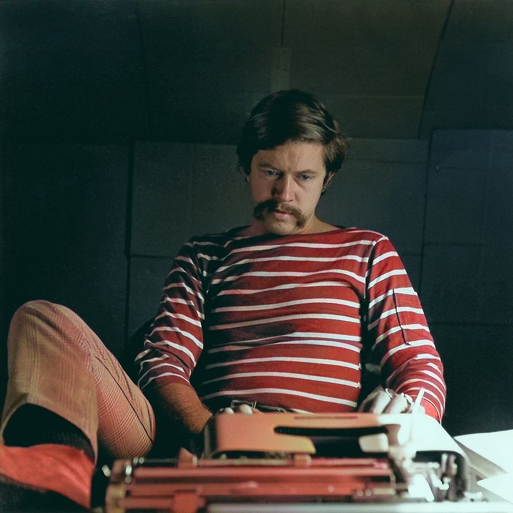 Tom Robbins in 1967 working on his novel "Another Roadside Attraction" in an office that appears to be made of cardboard.