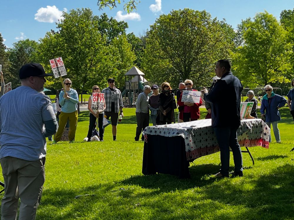 Keith Ellison speaking to a crowd holding signs