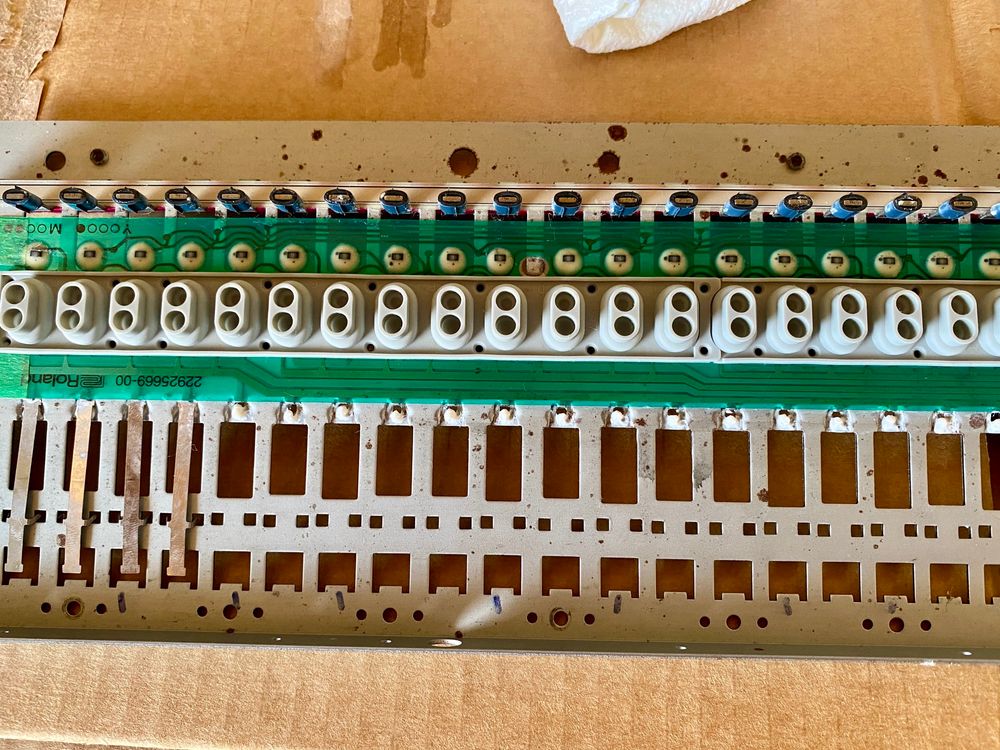 Key-spring stays, showing white lithium grease, for the internal keybed of the Roland JD800.