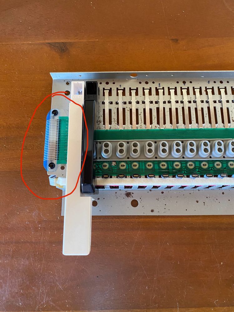 The left side (and lower octave) on the JD800 keybed, showing the plastic retaining clip that facilitates contact between a small PCB on the underside of the keybed and the upper flexible PCB.