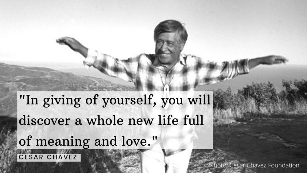 Black and white photo of Cesar Chavez outdoors with the quote, “In giving of yourself, you will discover a whole new life full of meaning and love.”