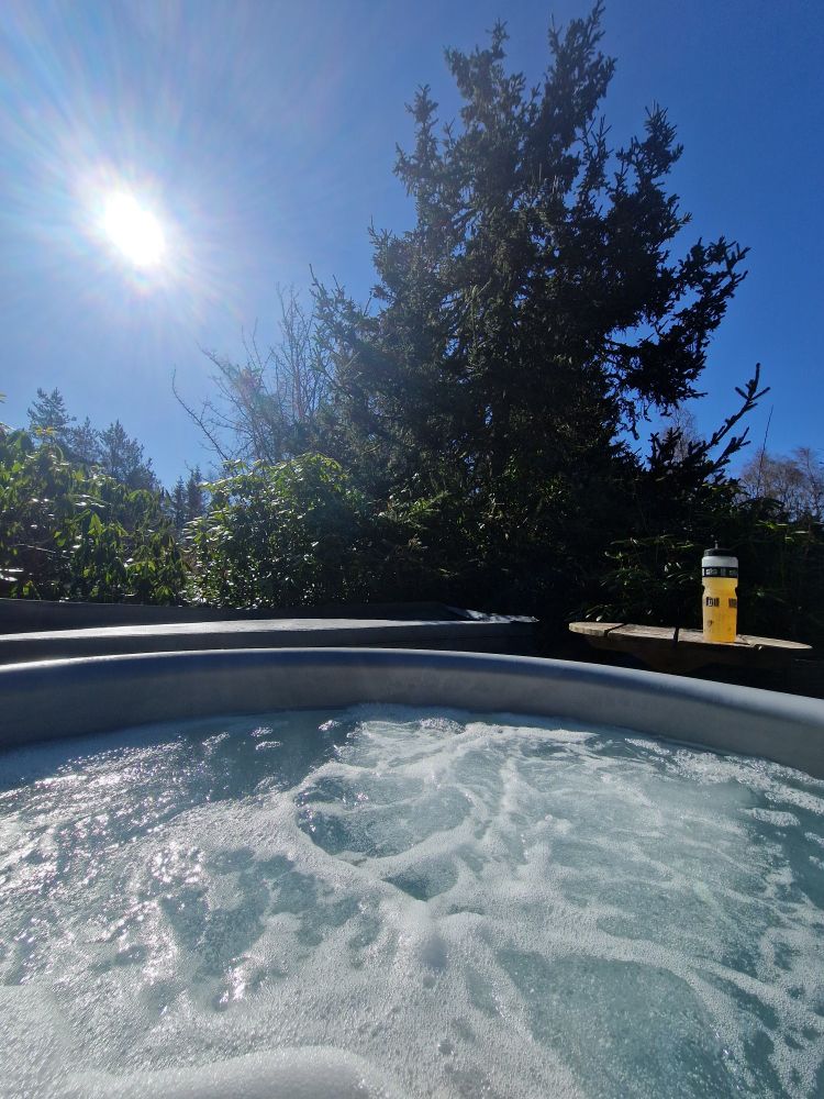 Post ride dip in the hotub in April Sunshine looking out at the forest