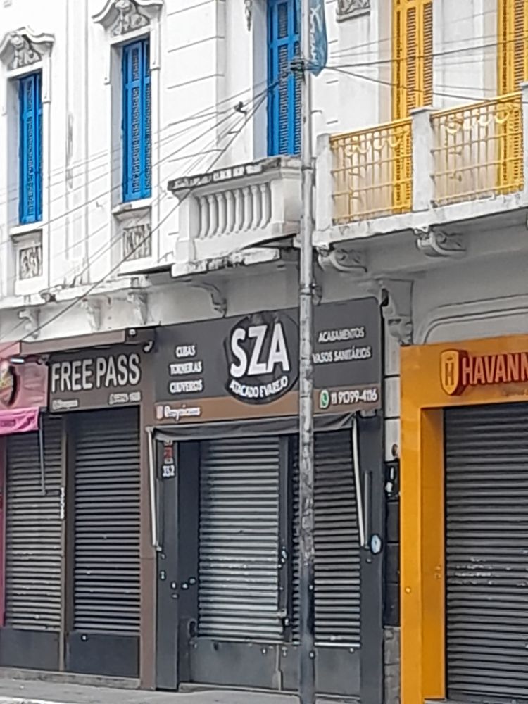 foto de uma loja fechada na rua santa ifigênia com um andar residencial em cima. o nome da loja é sza atacado e varejo 